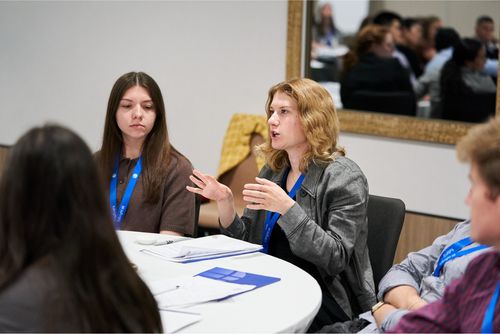 Photo of participants seated around a table discussing a project
