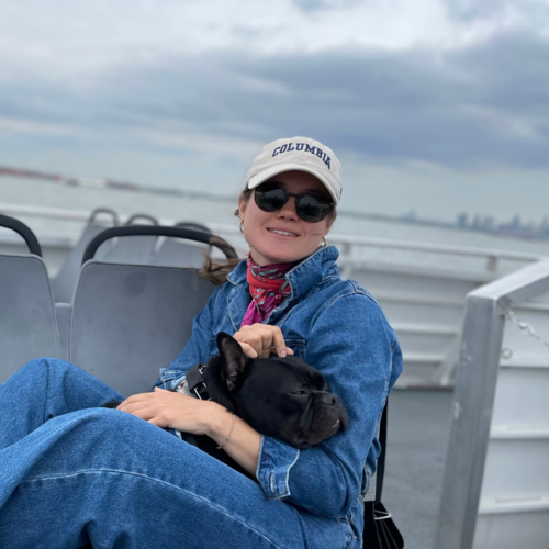 Photo of Sophie wearing Columbia University hat and holding dog