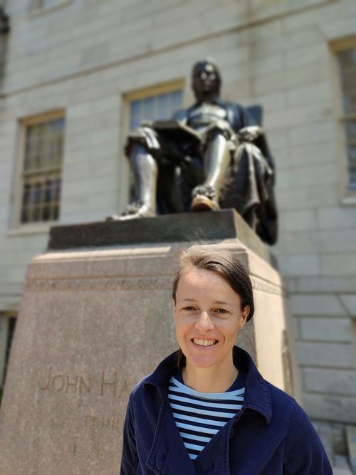 Photo of Karin Mayr Dorn in front of statue of John Harvard at Harvard University