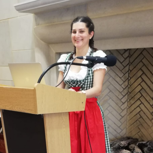 Photo of Sylvia Rainer smiling behind a lectern